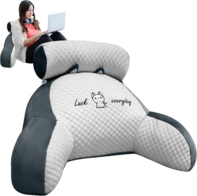 Large gray and white backrest pillow with 'Luck everyday' text, used by a person sitting on it.