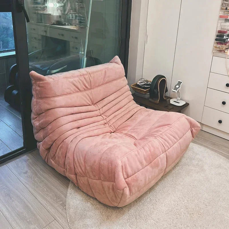 Pink cushioned chair in a room with a glass door and white cabinets.