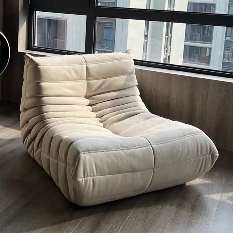 Beige lounge chair in a room with large windows