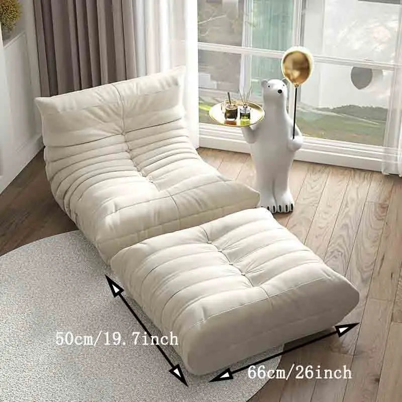 White lounge chair with dimensions displayed in a room with large windows.