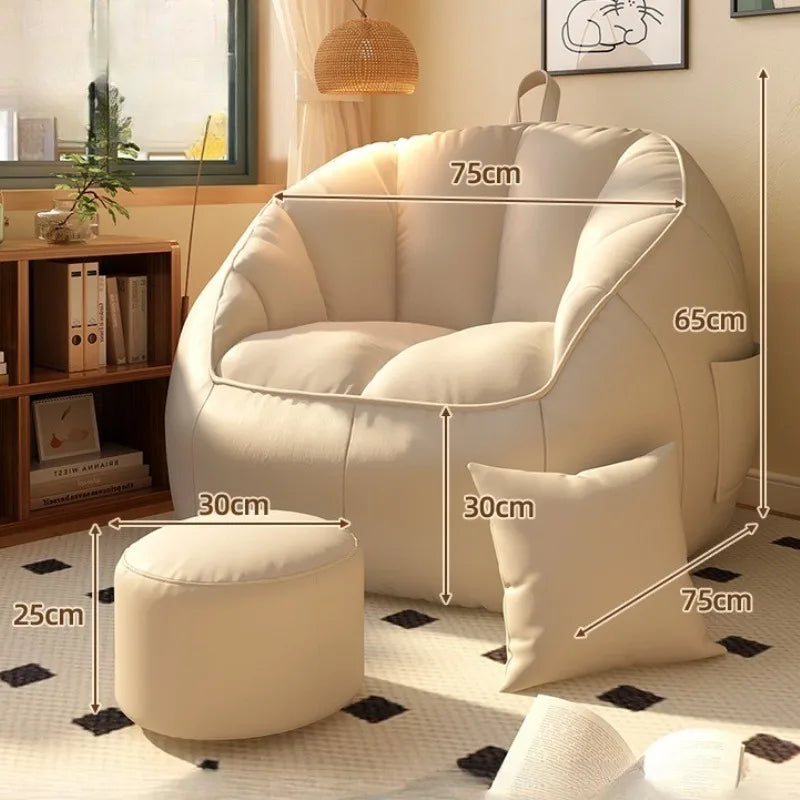 Beige armchair with ottoman and pillow, shown with dimensions in a living room setting.