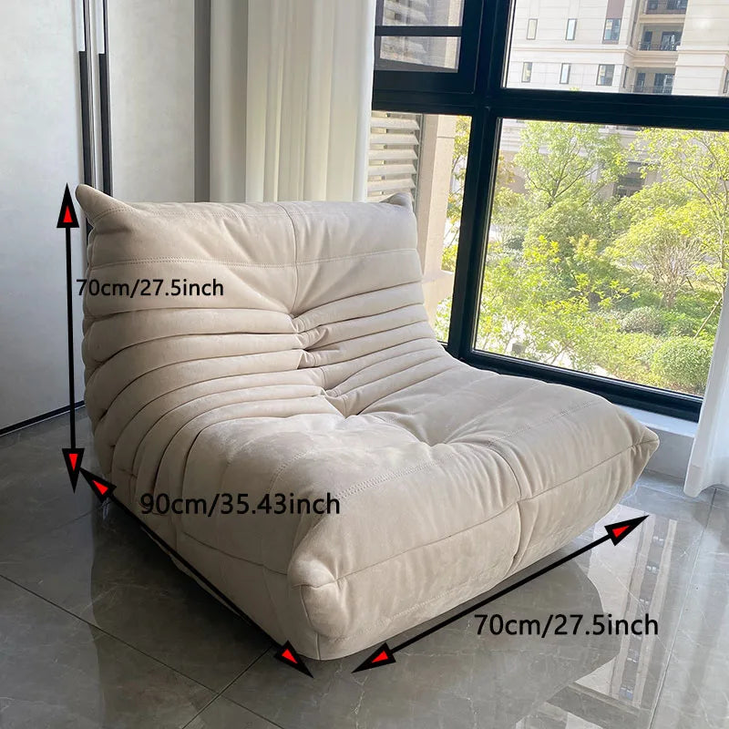 Beige lounge chair with dimensions marked in a room with large windows.