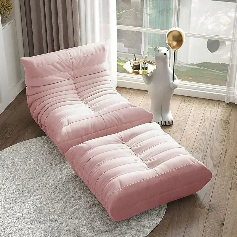 Pink floor sofa in a room with large windows and a decorative polar bear statue.