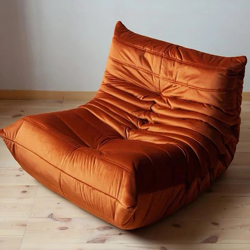 Orange bean bag chair on a wooden floor with a plain wall background