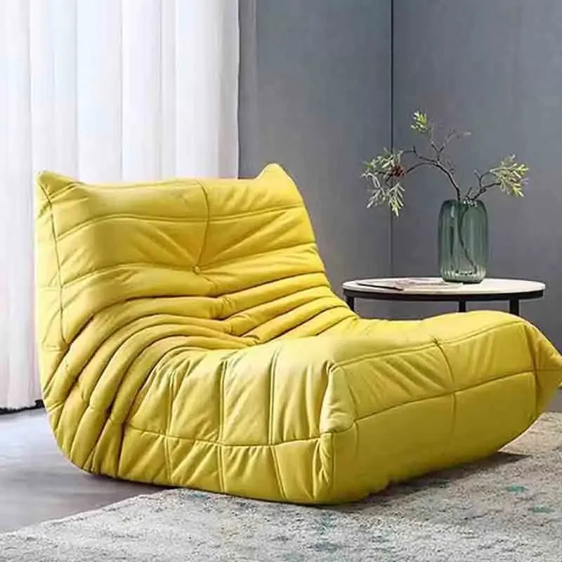 Yellow bean bag chair in a room with a side table and plant.