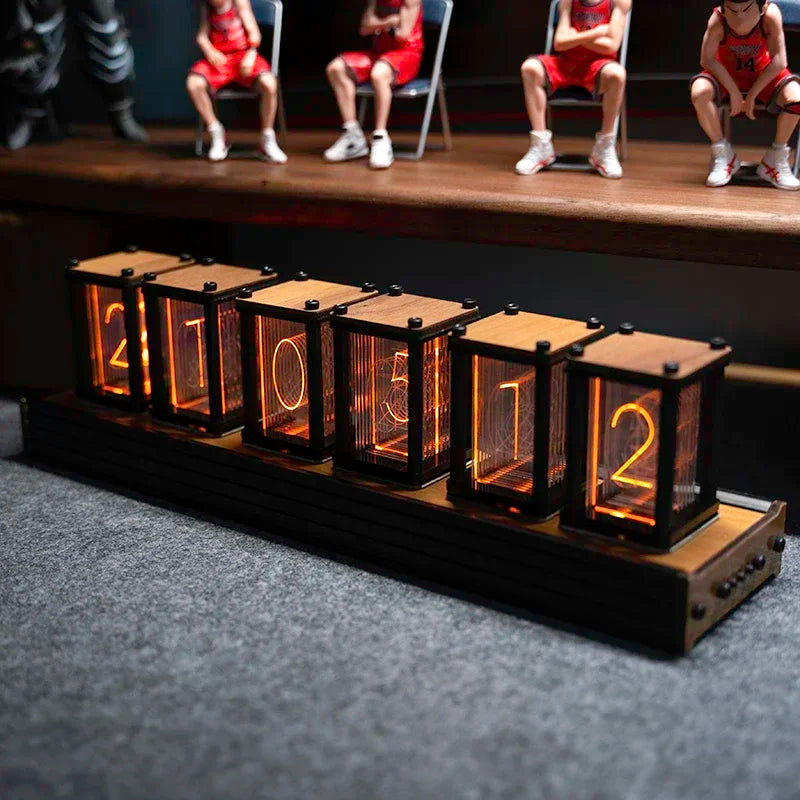 Digital clock with illuminated numbers on a dark surface, with a blurred background of people sitting.