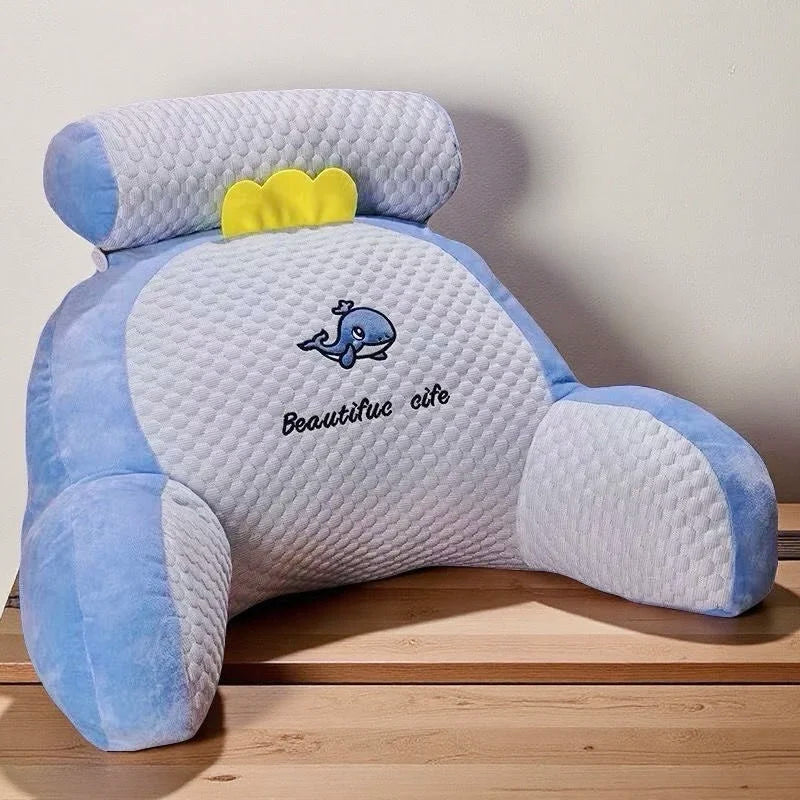 Blue and white pillow with a whale design and 'Beautiful elite' text on a wooden surface.