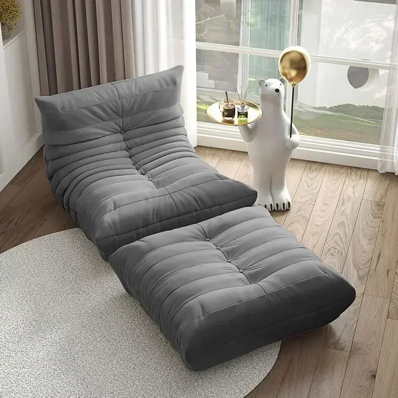 Gray floor sofa in a room with large windows and a decorative polar bear statue.