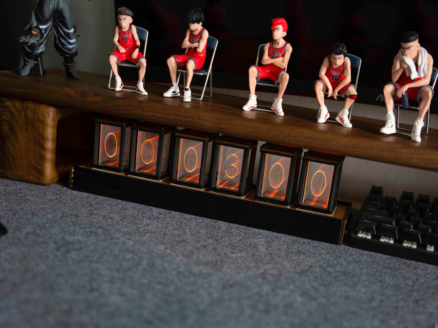Small figures of people sitting on chairs with numbered frames below them.