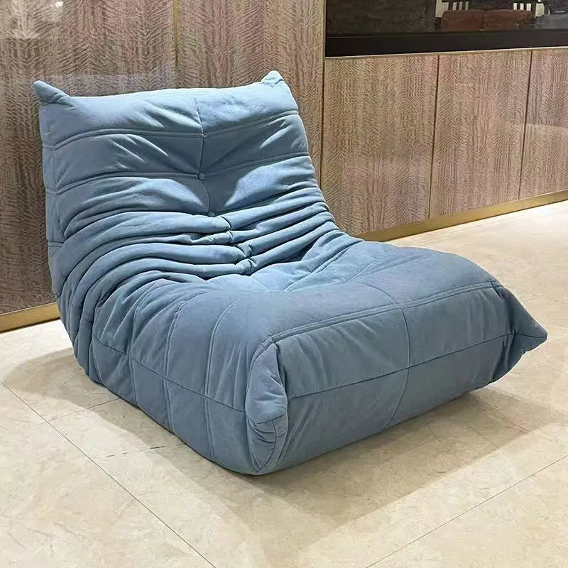 Blue bean bag chair on a tiled floor with wooden paneling in the background