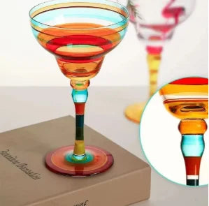 Colorful glass cocktail glass on a book with an inset showing a close-up of the glass.